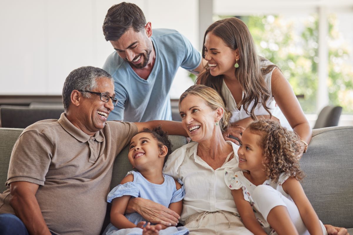 Intergenerational family smiling sitting on a sofa 