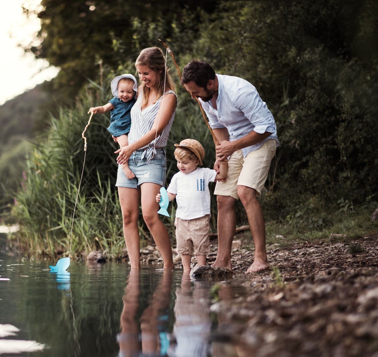 Family with 2 small children trying water in a lake